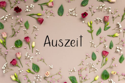 Flower Arrangement With German Text Auszeit Means Downtime. Colorful Spring Blossoms And Flowers Like Roses Building A Frame. Flat Lay With Brown Paper Background