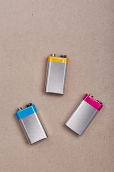 Three discharged batteries on paper background. Collecting used batteries to recycle. Waste disposal and recycling. Copy space for text