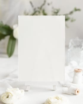 Blank Card near cream roses and white ribbons close up, Wedding mockup. Romantic scene with vertical card and flowers. Valentines, Spring or Mothers day concept