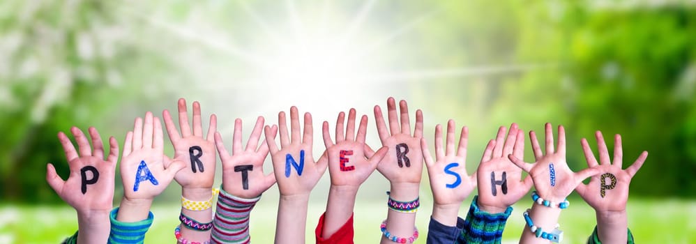 Children Hands Building Colorful English Word Partnership. Summer, Sunny Green Grass Meadow As Background