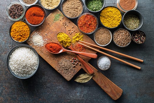 Colorful herbs and spices for cooking Asian dish. Chinese spices and ingredients on grey stone background. Top view.