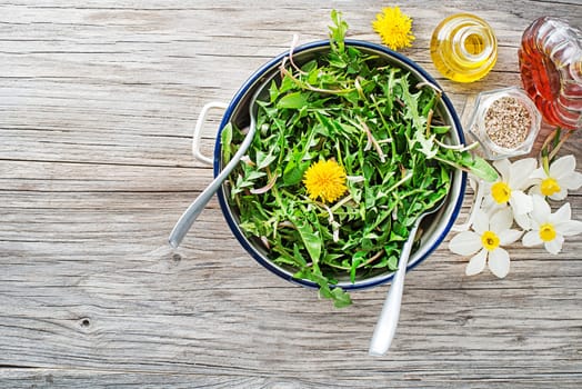 Fresh dandelion salad with dressing. Healthy spring food concept