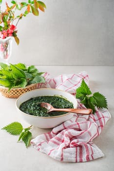 Nettle leaves for healthy dish on bright table background. Spring healthy detox food
