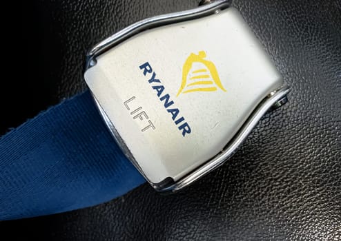 Dublin, IR Jan 2023: detail of the buckle of the seat belt with Ryanair logo on an empty seat. Ryanair is an Irish low-cost airline. Illustrative editorial.