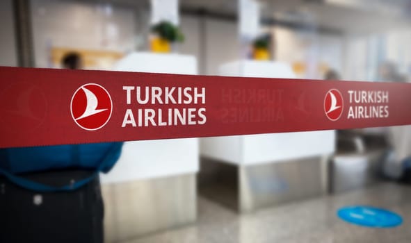 Istanbul, TR Jan 2023: Red retractable belt barrier with white Turkish Airlines logo. Turkish Airlines is the turkish flag carrier airline. Travel and airport security. Illustrative editorial
