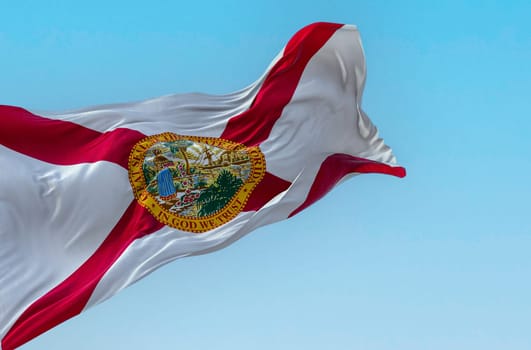 Close-up view of the Florida state flag waving in the wind on a clear day. Red saltire on white with the state seal in the center. 3d illustration render. Fluttering textile.