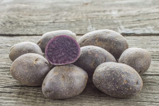 Purple potato from France on a wooden board