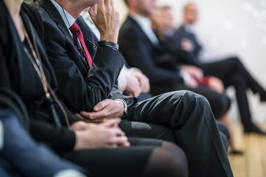 Row of unrecognizable business people sitting in conference hall at business event. Audience at business seminar. Business and Entrepreneurship concept.