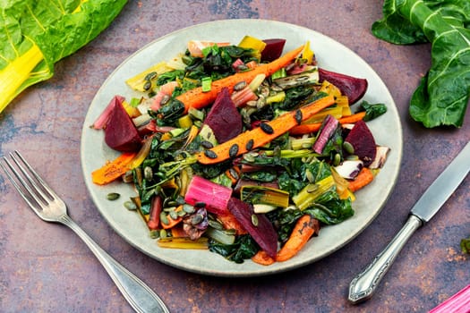 Salad of stewed chard, beetroot and carrots with pumpkin seeds. Vegetarian healthy food concept