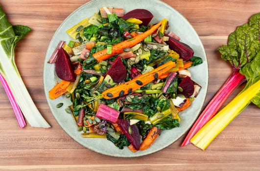 Salad of stewed chard, beetroot and carrots with pumpkin seeds. Vegetarian healthy food concept