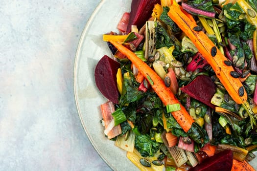Salad of stewed chard, beetroot and carrots with pumpkin seeds. Vegetarian healthy food concept