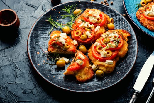 Chicken chops with tomato, olives and cheese.Chicken schnitzel