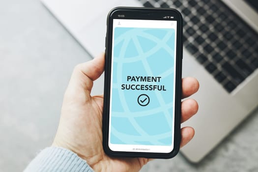 Man paying with smartphone for online shopping. Paying using fast secure payment system. Paying bills using express payment technology. Paying expenses online. Ordering product online using smartphone. Confirmation payment successful displayed in store app on smartphone screen. Express payment