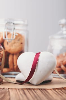 Gingerbread cookies, candies, cakes, sweets in jars on wooden table. Portrait orientation