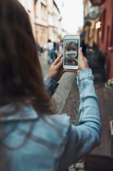 Young woman having video call talking while walking downtown wearing the face mask to avoid virus infection and to prevent the spread of disease in time of coronavirus