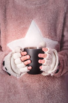 Female hands holding mug with hot drink