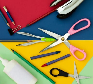 Office or school supplies on a colorful background. Top view
