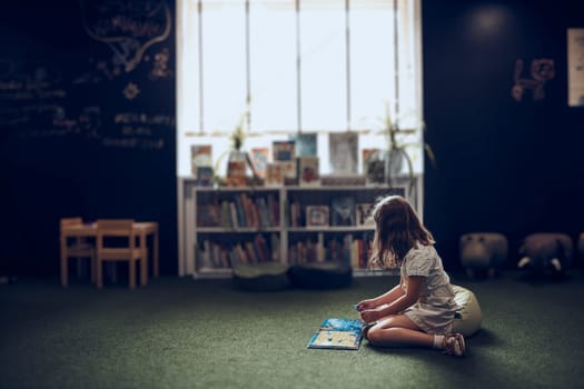 Child solving riddle in book in school library. Primary school pupil is involved in book with riddles. Smart girl learning to solve problems. Benefits of everyday practice. Child curiosity