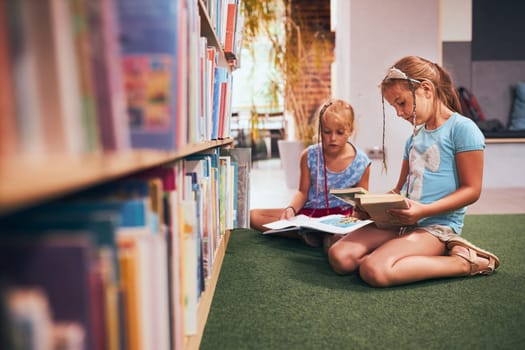 Schoolgirls looking for book for reading in school library. Students choosing books for reading. Learning from books. Back to school. Elementary education. Doing homework