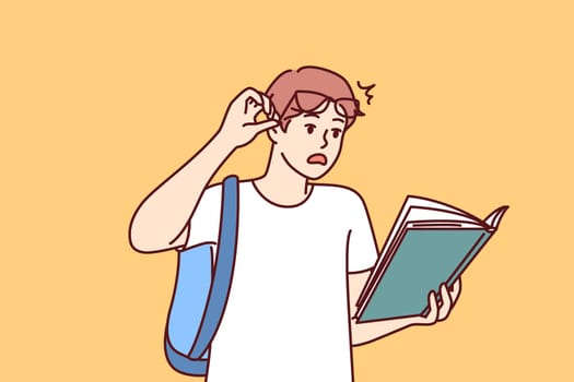 Shocked guy student with book reads amazing smart facts in textbook which causes wow effect. Young man lifts glasses from eyes after reading shocking information in book given by college teacher