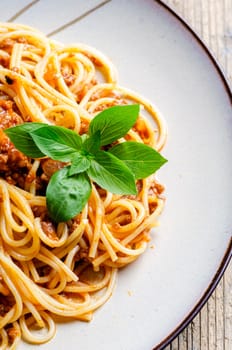 Plate of spaghetti bolognese from above. Italian pasta with meat, tomato, cheese and basil closeup. Traditional Mediterranean cuisine recipe. Italian restaurant dish menu.