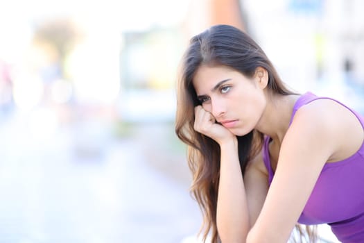 Bored woman waiting sitting in the street