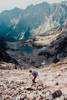 Young man hiking alone along a rocky trail in the mountains