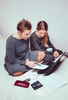 Woman and her daughter planning budget at home