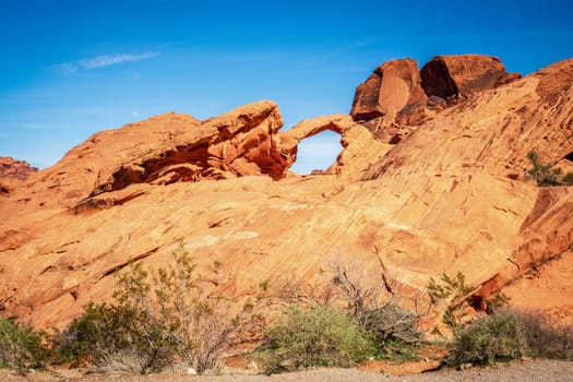 Moon rising over Arch Rock formation in Valley of Fire State Park in Nevada