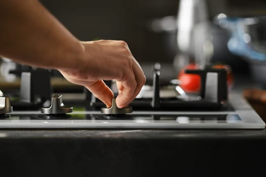 Hand switching on gas on a stove, use of piezoelectric ignition