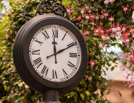oldfashioned railway station clock pointing ten past noon