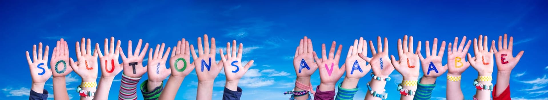 Children Hands Building Colorful English Word Solutions Available. Blue Sky As Background