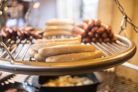 Grilling sausages on barbecue grill at a food stall of Christmas market