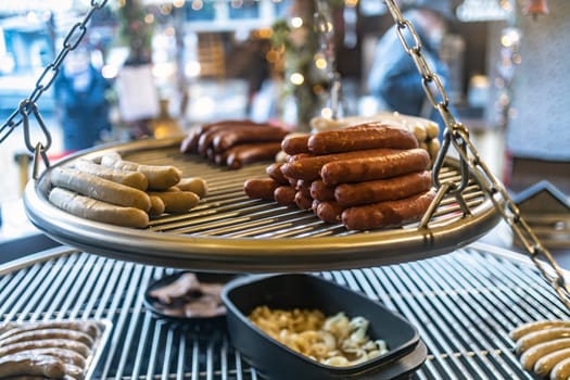 Grilling sausages on barbecue grill at a food stall of Christmas market