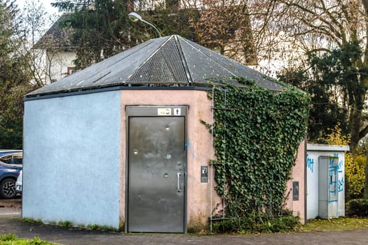 Public toilet in a city with graffiti and metal door