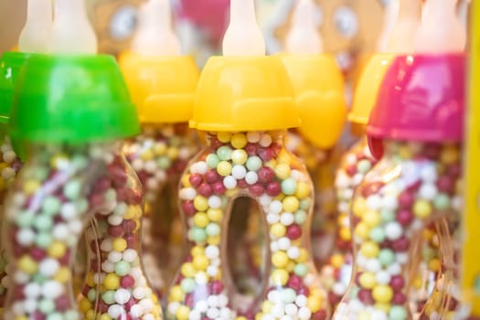 Blurry close up from sweet candy love pearls in plastic bottle in a row