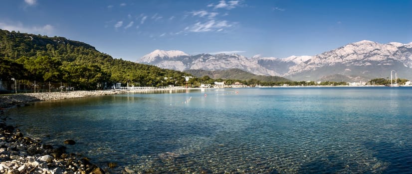 Kemer Antalia nice view of the sea. Beach Kemer Antalia with sand and mountains, the sea with the ship. Beautiful harbor near the sandy beach.