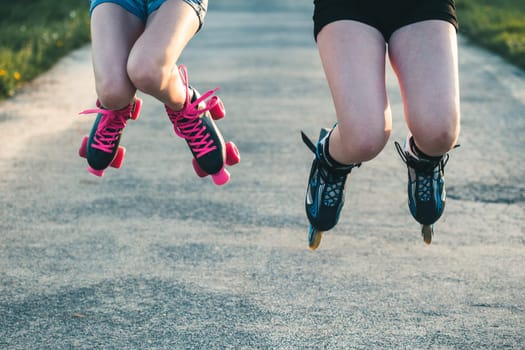 Teenage girls having fun rollerskating, jumping, spending time together on summer day