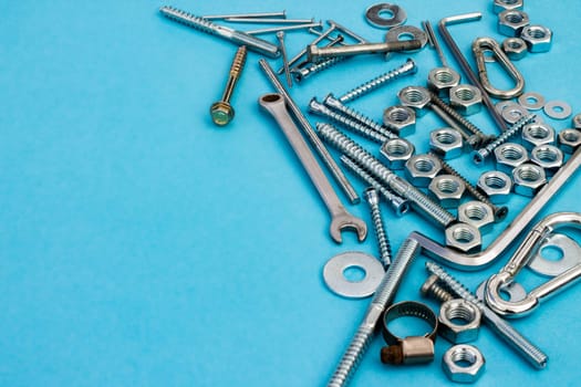 Bolts, nuts, wrenches and other construction tools on a blue background. Father's day concept. Copyspace