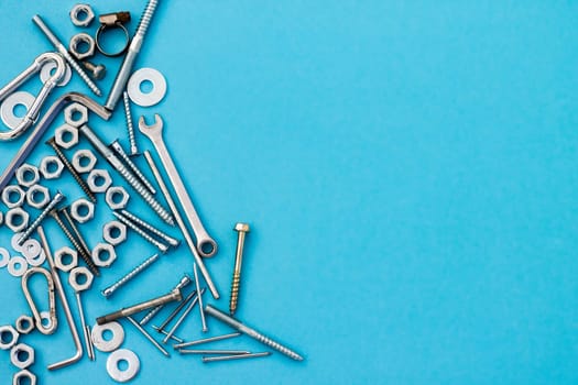 Bolts, nuts, wrenches and other construction tools on a blue background. Father's day concept. Flat lay. Top view. Copyspace