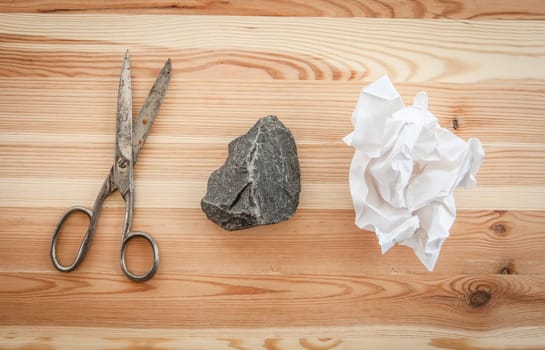 Scissors,stone and paper on rustic wooden background