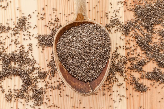 Chia seeds in rustic loeffel on wooden background