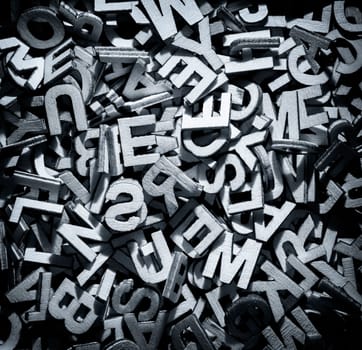 Pile of wooden letters in English and monochrome in a random layout