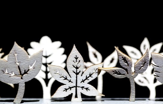 Tree and leaf wooden shapes on a black background