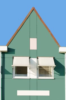A Dutch house with a triangular roof gable,rain gutters and sun protection.