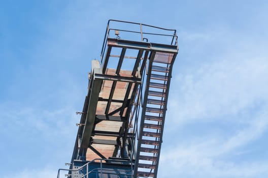 Detail View of a factory tower in front of a blue sky