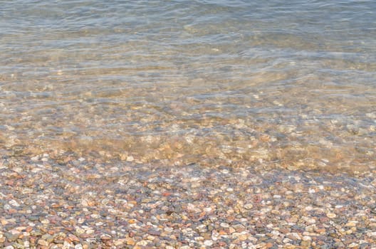 Shoreland,overlooking small pebbles in a clear river.
