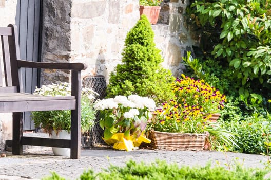 Beautiful Mediterranean house entrance with bench and colorful flowers..