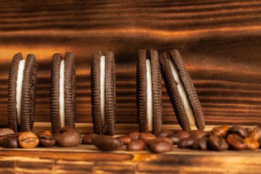 Cookies on a brown background of a burnt tree with coffee grains scattered on the table. Side view, copy space