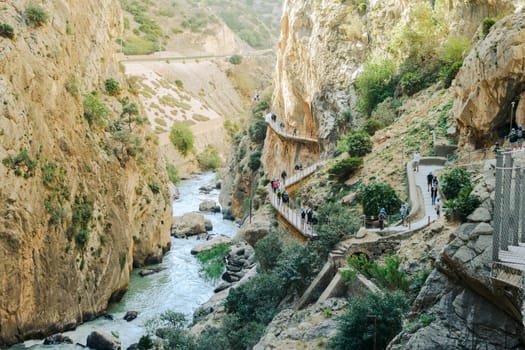 El Chorro, Spain, April 2023: People walking the Caminito Del Rey in the Desfiladero de los Gaitanes, a gorge carved by the Guadalhorce river in the province of Málaga, Spain